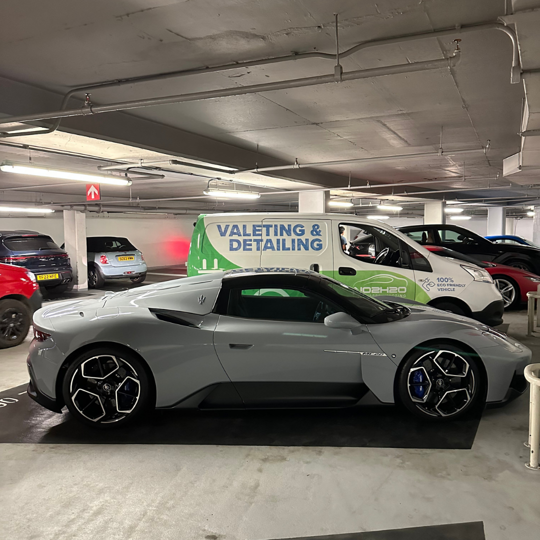 NO2H2O valeting and detailing van with a grey Maserati MC20 in a London underground car park